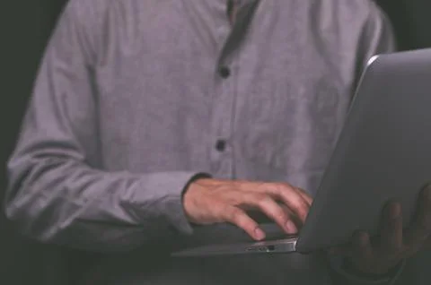 A standing man using a laptop computer Stock Photos