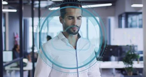 Standing man wearing white button-up shirt using blue cloud HUD in open office, Stock Photos