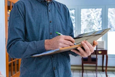 Standing man writes on notebook inspector holding a notebook in his hand. ... Foto stock
