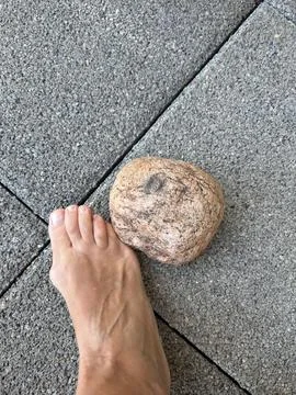 Standing next to a stone on the sidewalk Stock Photos
