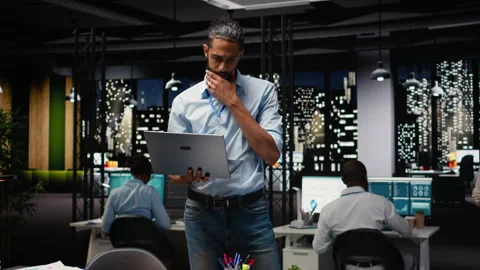 Standing in office, arab manager holds laptop, evaluating performance data Stock Footage 334040338