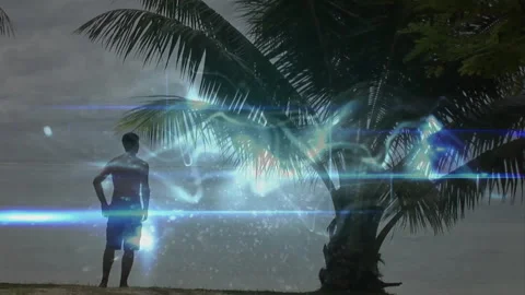 Standing by palm tree, man observing animation of abstract light patterns in sky Stock Footage 305262619