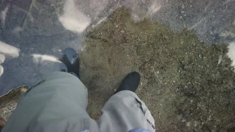 Standing in a river with rubber boots tilt up 4K Stock Footage 135167985