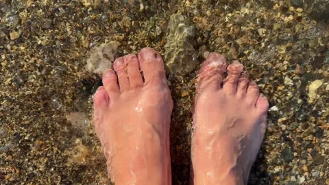 Standing on a rock while feeling the waves wash over your feet. Stock Footage 310141648