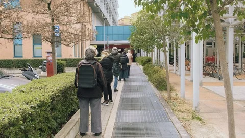 Standing in a row to go inside a supermarket, with safety distance to Stockbeeldmateriaal 126565486