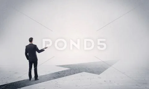 Standing salesman looking ahead with arrow Stock Photos