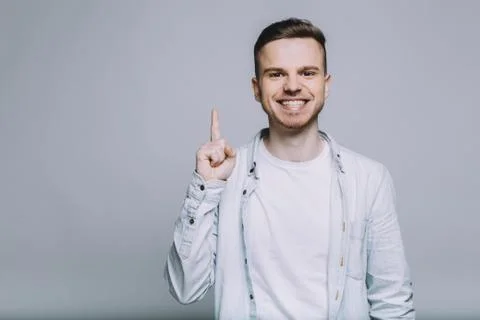 Standing smiling young man with beard in a white shirt Foto stock