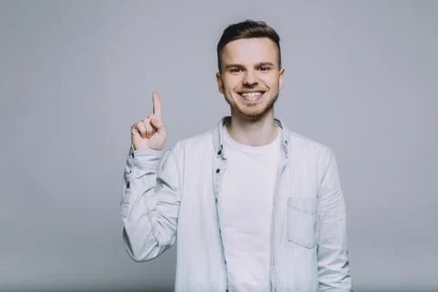 Standing smiling young man with beard in a white shirt Stock Photos