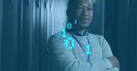 Standing tech arms crossed in data center, gray sweater, blue lanyard, server Stock Photos