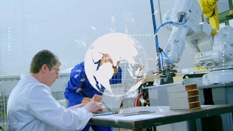 Standing tech leaning and pointing, both techs verifying robotic arm wiring with Stock Footage 335739386