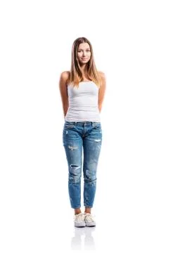 Standing teenage girl in jeans and white singlet,  isolated Stock Photos