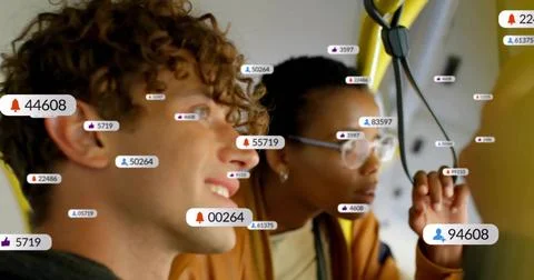 Standing two riders wearing jackets looking at right window on bus near yellow Stock Photos