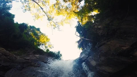 Standing under a waterfall with a local guide in Cambodia, Kampot Stock Footage 100785675