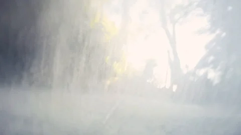 Standing under a waterfall with a local guide in Cambodia, Kampot Stock Footage 100787116