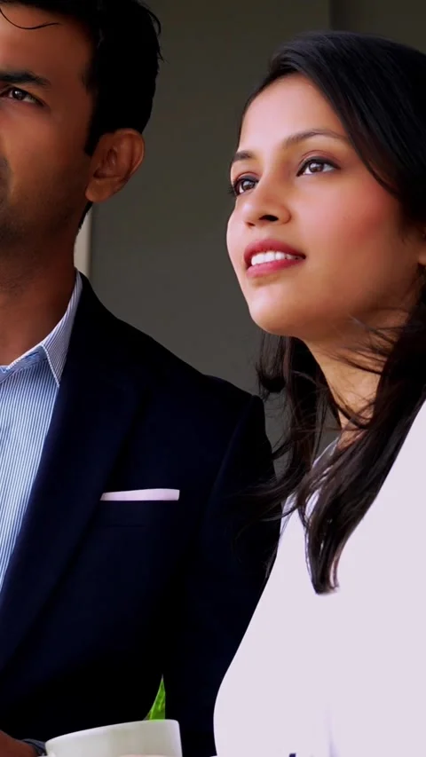 Standing at window with coffee mug, Indian coworkers chat during office break Stock-Footage 342559787