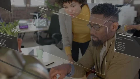 Standing woman pointing causing code overlays on laptop while seated man tapping Stock Footage 333369134