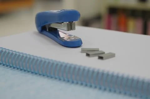 Stapler and staples on notebook Stock Photos
