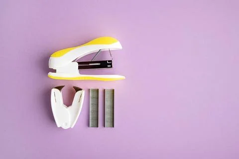 Stapler and staples on purple background Stock Photos