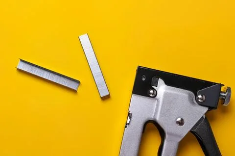 Stapler and staples on yellow background Stock Photos
