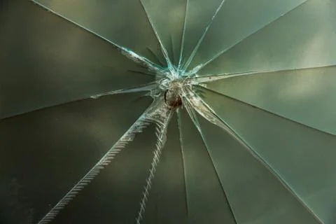 Star blast cracks in the glass panel. Broken glass texture. Deep realistic gl Stock Photos