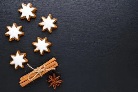 Star cookies on black background with cinnamon, anise and copy space Stock Photos