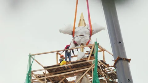 Star fixed on ropes stands on crane elevating platform Vídeo Stock 257563394