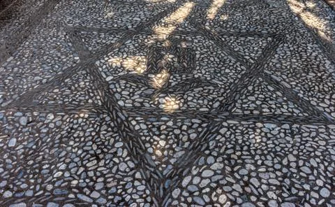 Star pattern with a rose on a stone walking path at the Alhambra palace in Gr Foto stock