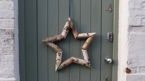 Star shape made out of silver birch tree branches hanging on door Stock Photos