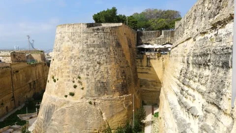Star shaped bastion corner rises above a cafe terrace umbrellas dotting the Stock Footage 341802891