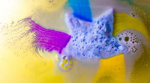 The star-shaped bath bomb dissolves with multicolored paints in water Stock Photos