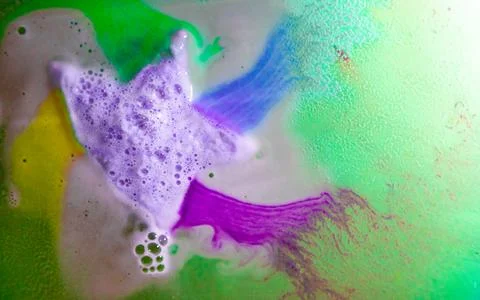 The star-shaped bath bomb dissolves with multicolored paints in water Stock Photos