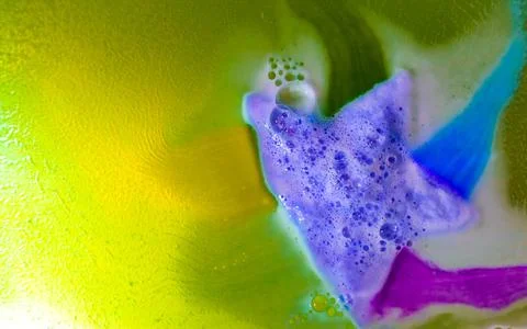 The star-shaped bath bomb dissolves with multicolored paints in water Stock Photos