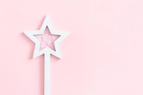 Star shaped magic wand with sequins on a pink pastel background Foto stock