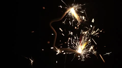 Star shaped sparkler burning with bright golden sparks on black background Stock Footage 336487756