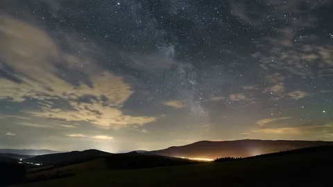 Star sky with milky way galaxy and clouds moving over rural landscape time lapse Stock Footage 70972761