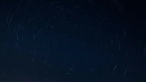 Star trails rotating in the night sky over a dark celestial background Stock Footage 342243975