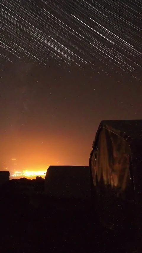 Star trails sweep above Mount Ararat base camp tents, orange city glow on h.. Stock Footage 317761002