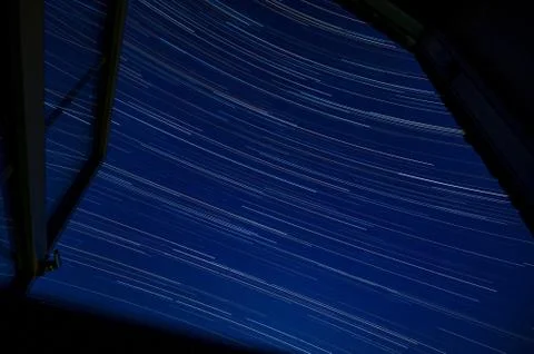 Star trails through a window looking south Stock-Fotos