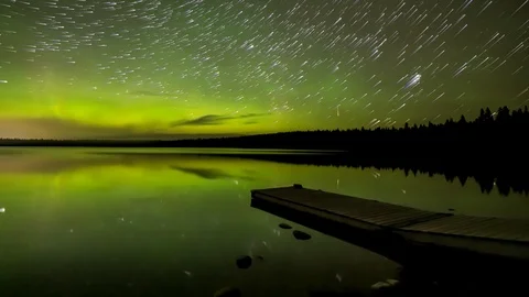 Star Trails time lapse of vivid Aurora and stars over and reflecting in a calm l Stock Footage 118410097
