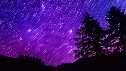 Star trails timelapse galaxy night sky over mountain. Blue and purple sky. 4K Stock Footage 77979595
