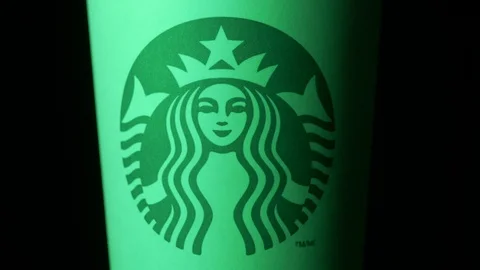 Starbucks coffee cup rotating in styled Christmas green light medium CU shot Stock Footage 108190576