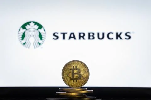Starbucks logo on a computer screen with a stack of Bitcoin crypto Stock Photos