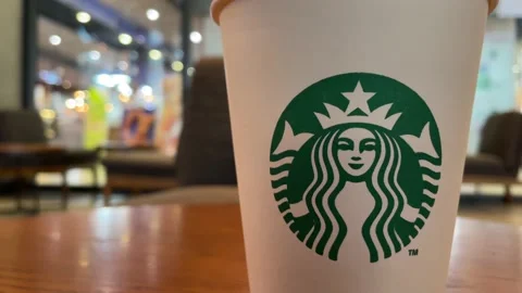 Starbucks logo on white paper cup inside the cafe at the mall, Bangkok Stock Footage 232087467