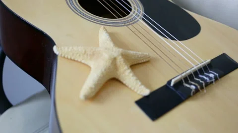 Starfish lying on the guitar. Close-up, front view, camera focus moves, indoors, Stock Footage 87042247