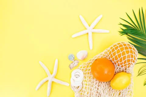 Starfish, shells with bag string bag with oranges and lemon with palm branch Foto stock