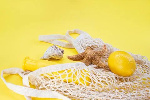 Starfish, shells with bag string with sunscreen bottle mockup and lemon Stock Photos