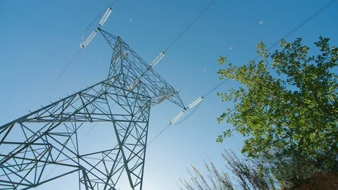 Staring up at tall electrical tower in blue sky on windy day, low angle Stock-Footage 123137099