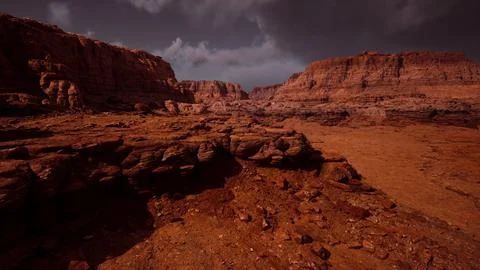 Stark reddish landscape with rugged rock formations under dark clouds in dese 库存插图
