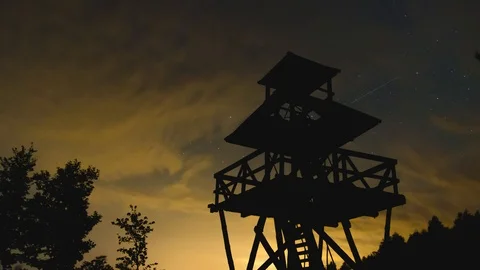 Starry night and fast moving clouds behind observation tower timelapse Vídeos de archivo 85636884