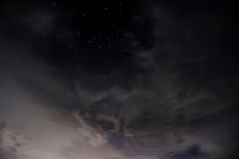 Starry Night Peaks through the Clouds Stock Photos